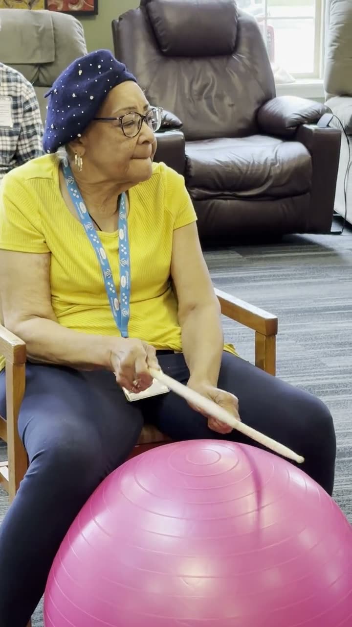 Participant enjoying a drum fitness activity on an exercise ball