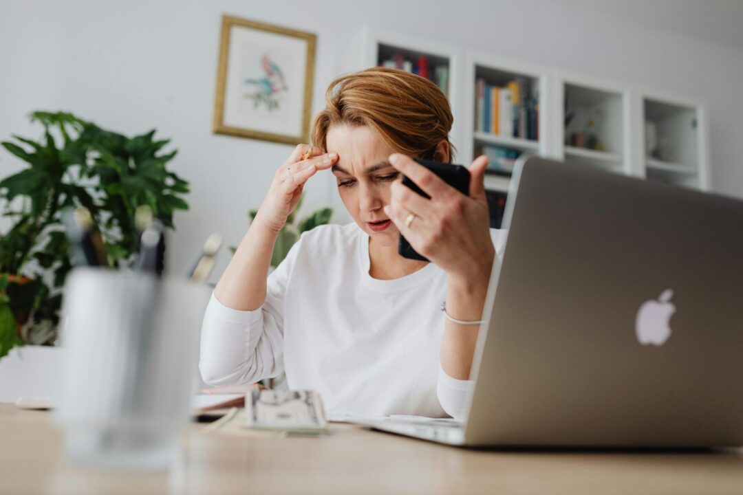 Working caregiver balancing a laptop and phone call
